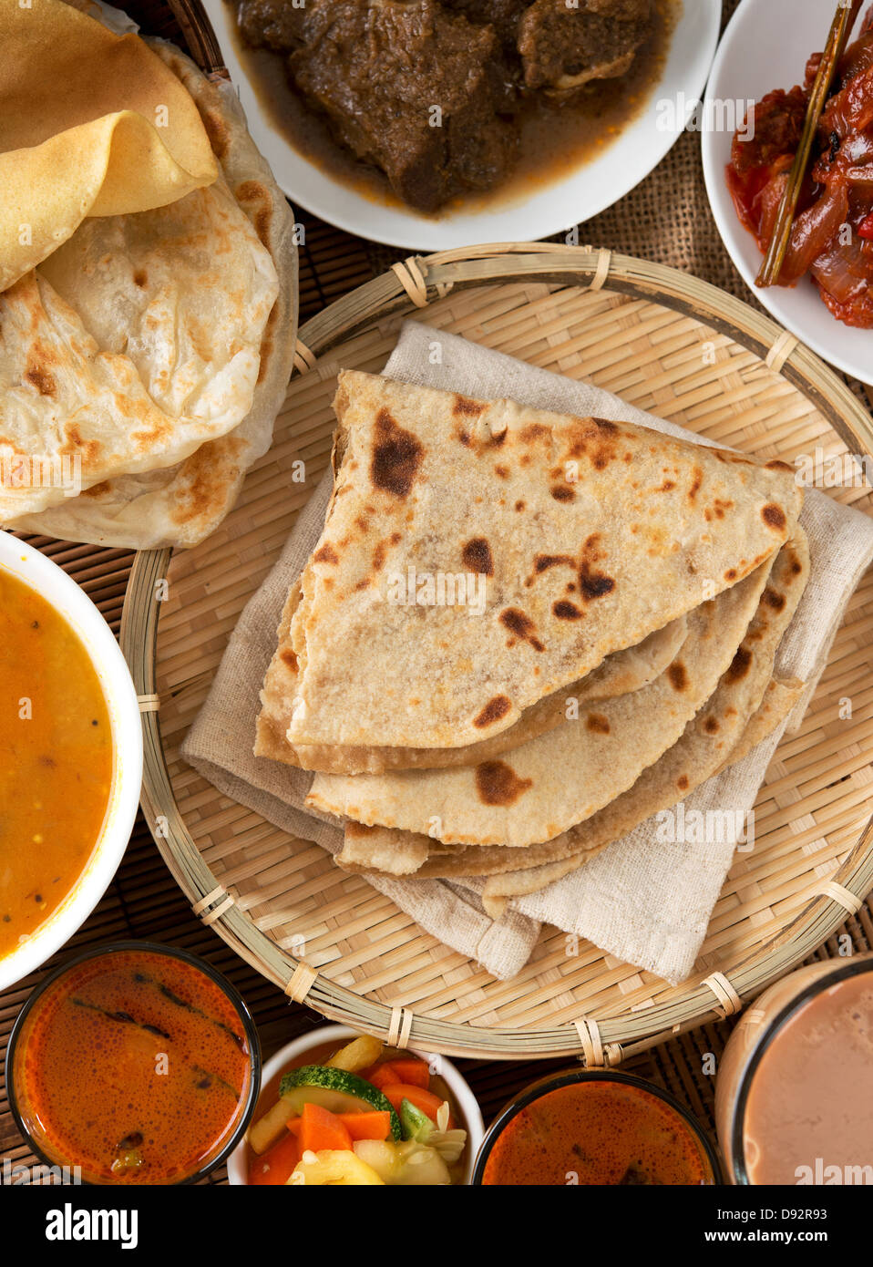 Indian bread, Chapati flatbread, roti canai, dal, curry, teh tarik or pulled tea, acar. Famous indian food. Stock Photo