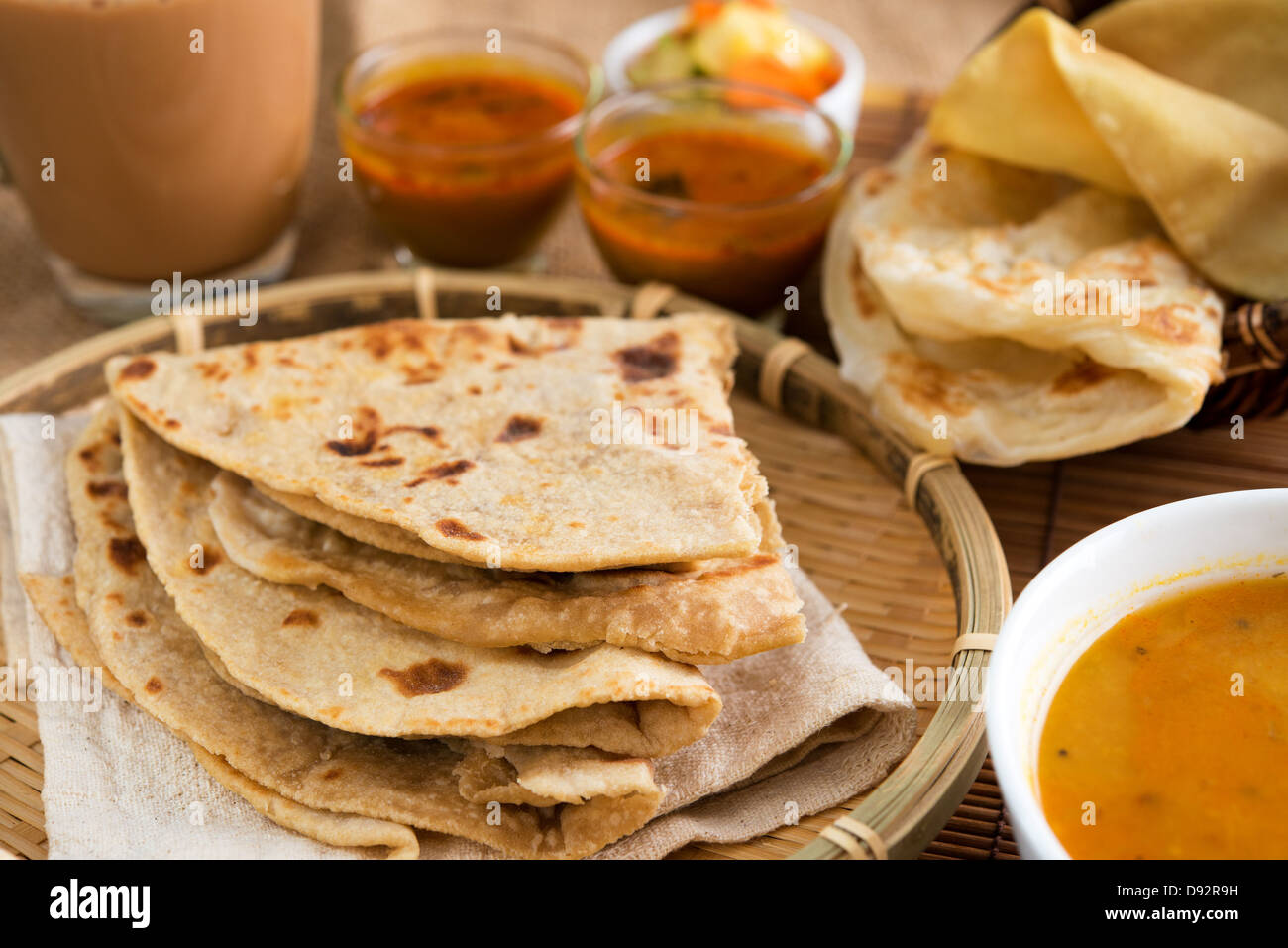 Indian food, Chapati flatbread, roti canai, dal, curry, teh tarik or pulled tea, acar. Famous indian cuisine. Stock Photo