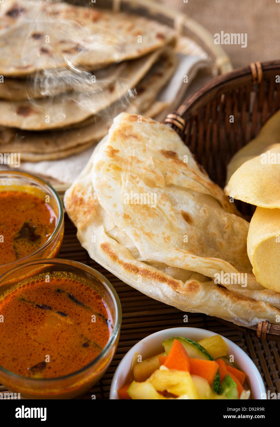 Indian meal, Chapati flatbread, roti canai, dal, curry, teh tarik or pulled tea, acar. Famous indian food. Stock Photo