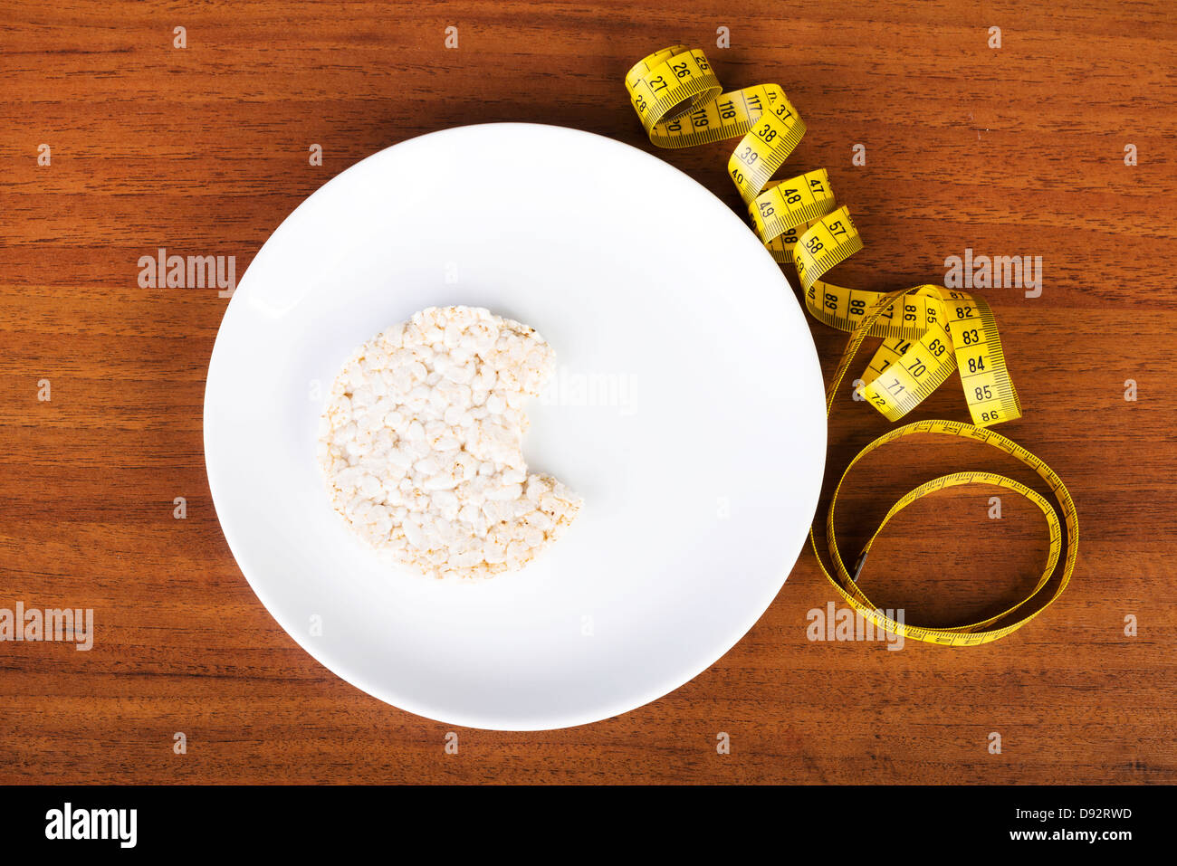 Diet concept. Biten rice cake on plate next to measuring tape Stock ...
