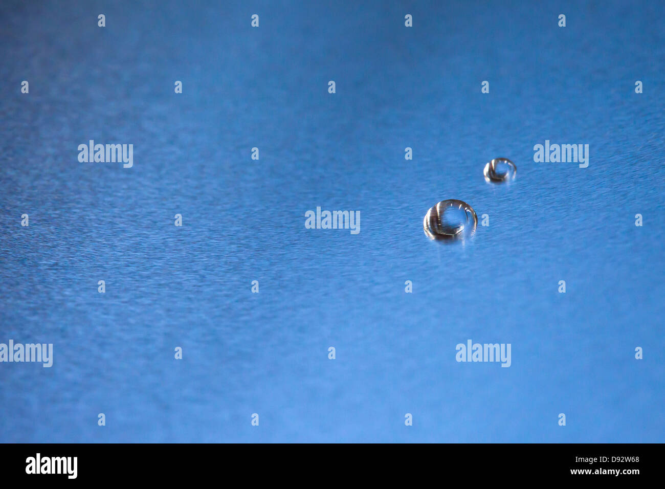 Two water drops on a blue background Stock Photo - Alamy