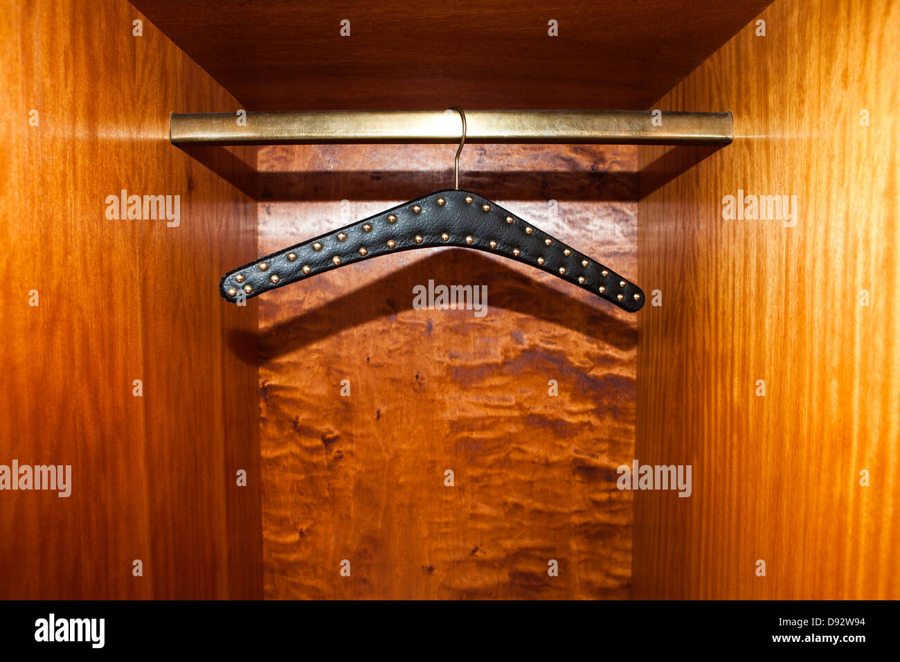 Studded leather belt hanger in wardrobe Stock Photo
