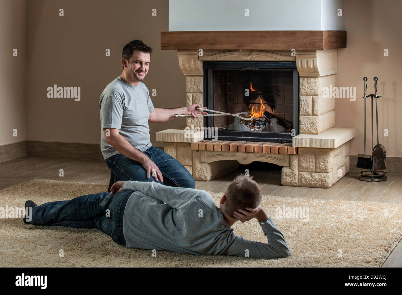 Father and son relaxing next to fire Stock Photo