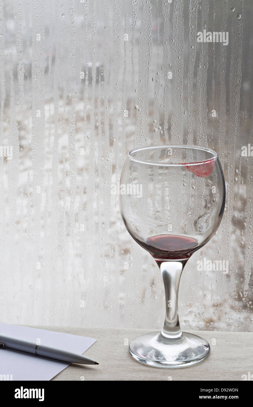 Lipstick stained wine glass beside pen and paper Stock Photo Alamy