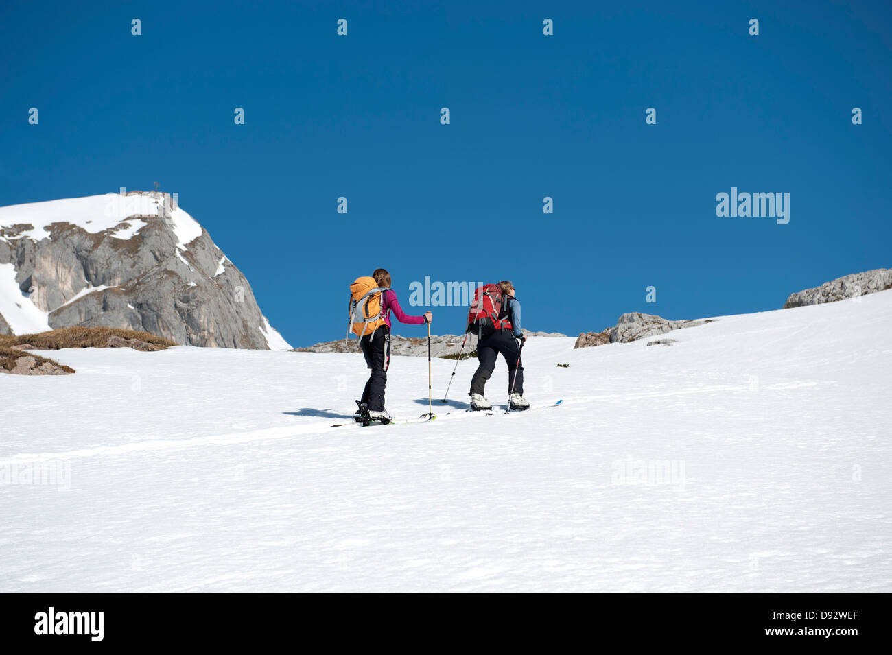 Two skiers moving up a snowy hill on The Dolomites, South Tyrol, Italy, Stock Photo