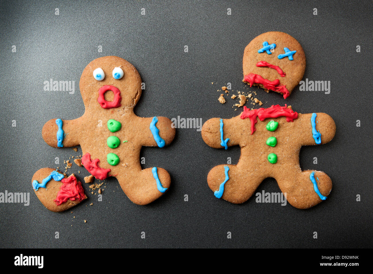 A shocked gingerbread man with broken leg next to a decapitated gingerbread man Stock Photo