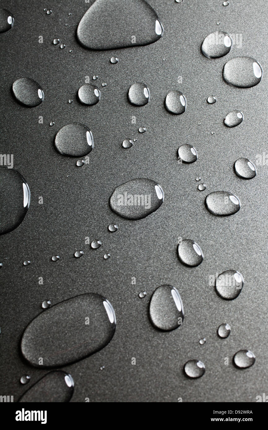 A pattern of various shaped water drops on a nonstick baking sheet Stock Photo