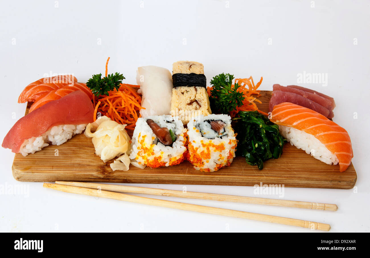assorted sushi and sashimi on a wooden plate with soy and chopsticks Stock Photo