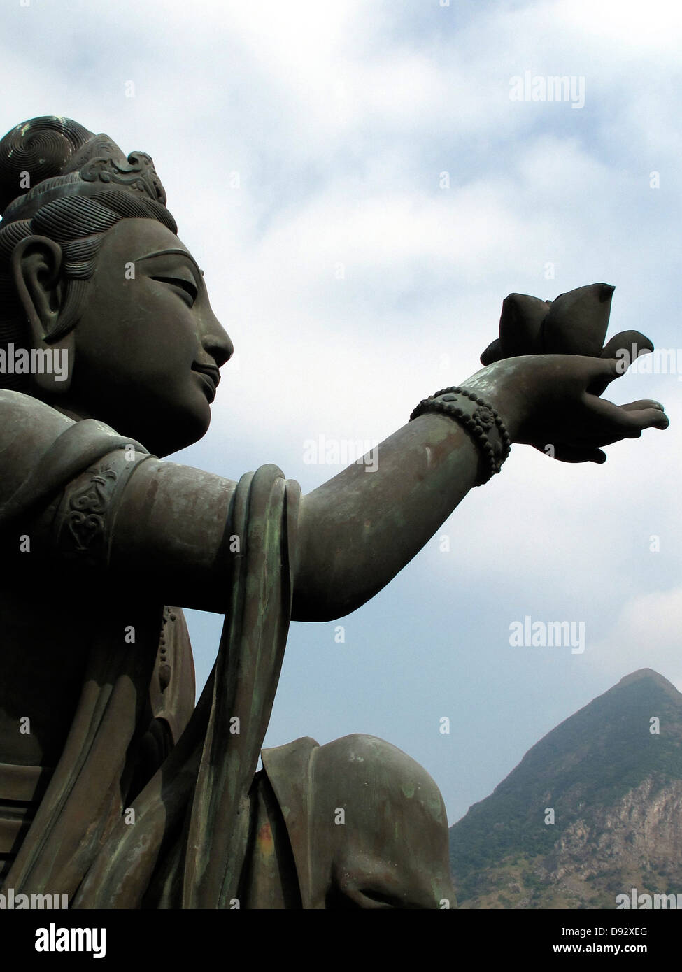 A statue offering a lotus flower to the Big Buddha, Lantau Island, Hong Kong Stock Photo