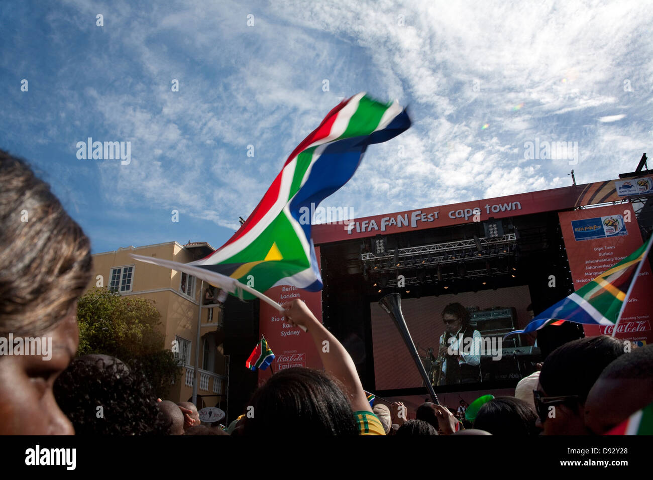 Football fan waves South African flag during live concert as part FIFA world cup final draw festivities on Long Street in Cape Stock Photo