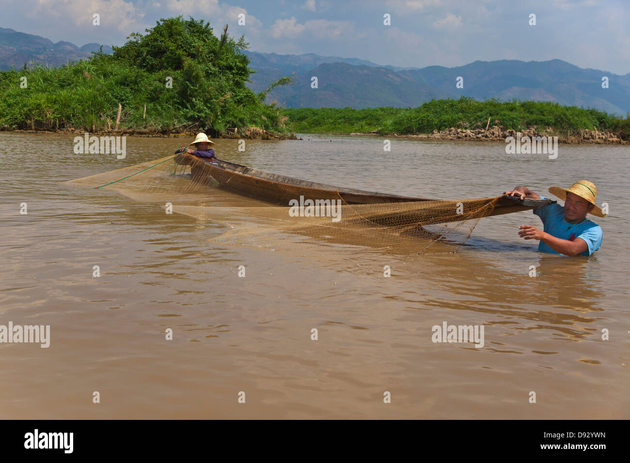 Fishing is still done in the traditonal way with small wooden boats and fishing nets - INLE LAKE, MYANMAR Stock Photo