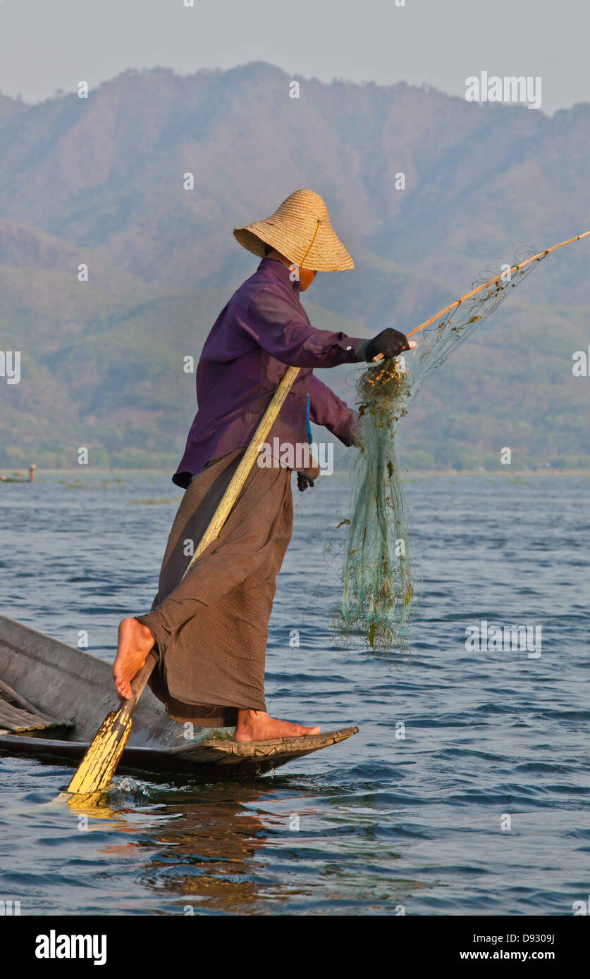 Fishing is still done in the traditonal way with small wooden boats, fishing nets and leg rowing - INLE LAKE, MYANMAR Stock Photo