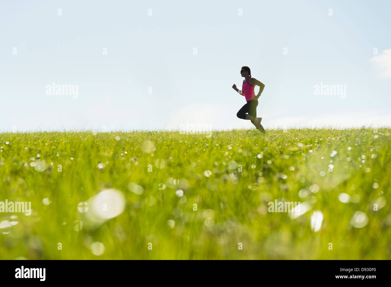 Woman jogging in meadow Stock Photo