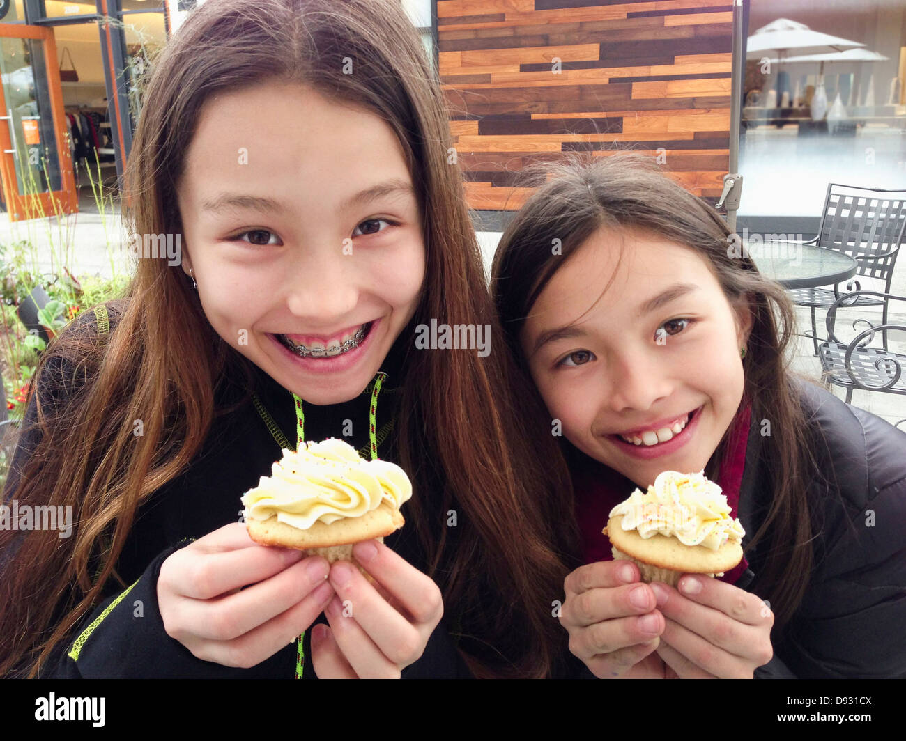 Mixed race girls eating cupcakes together - Smartphone Captured Stock Image