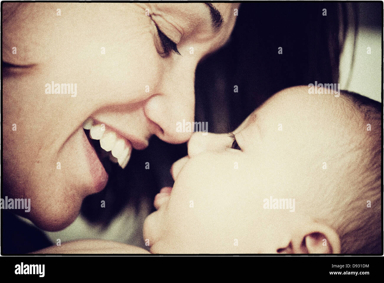 Hispanic mother touching noses with baby - Smartphone Captured Stock Image