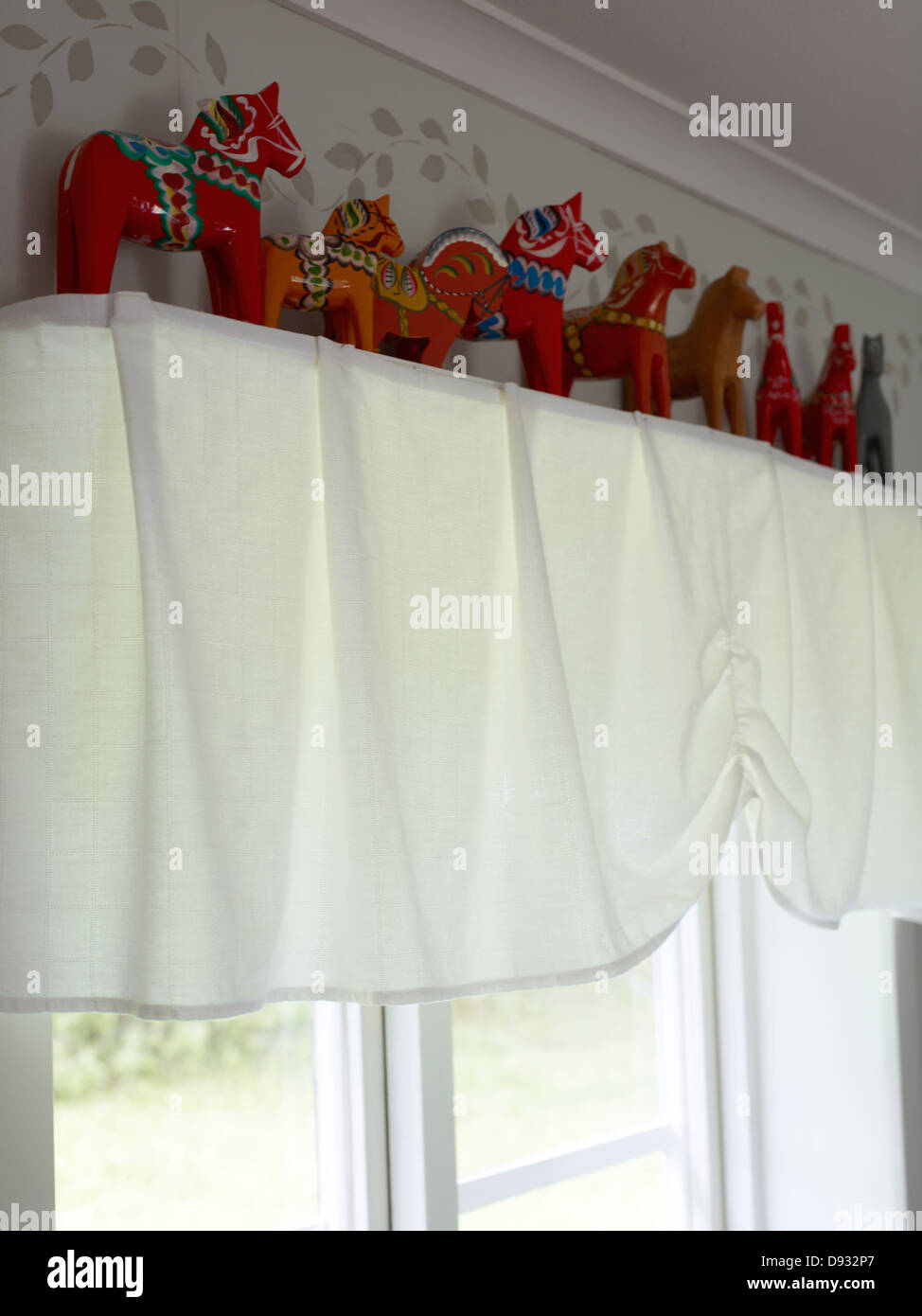 Traditional Scandinavian toy horses on shelf above window Stock Photo