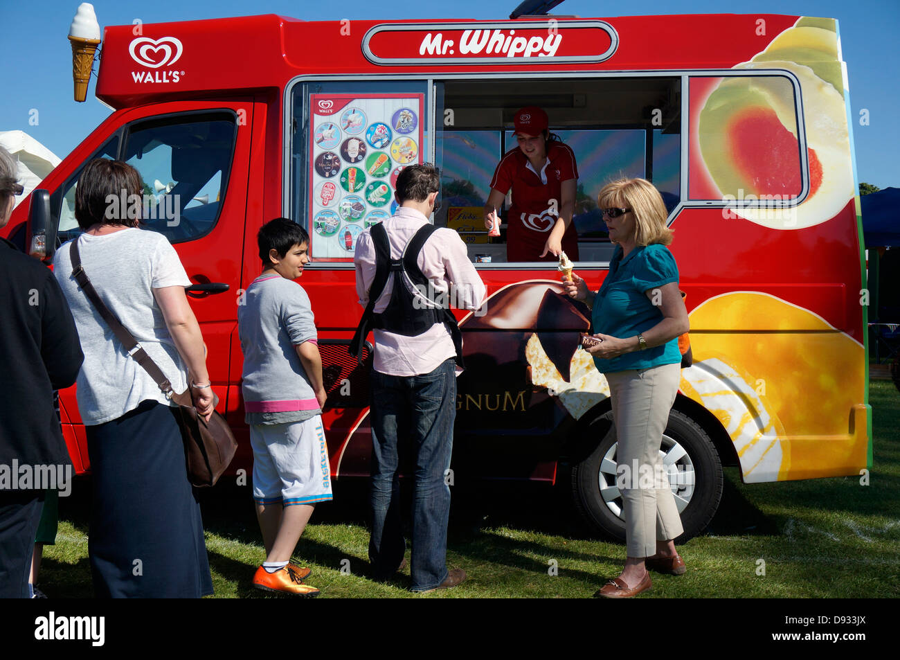 Customers queuing for traditional Wall's Mr Whippy ice cream, from a parked vehicle, outside on a hot summer day. England, UK. Stock Photo