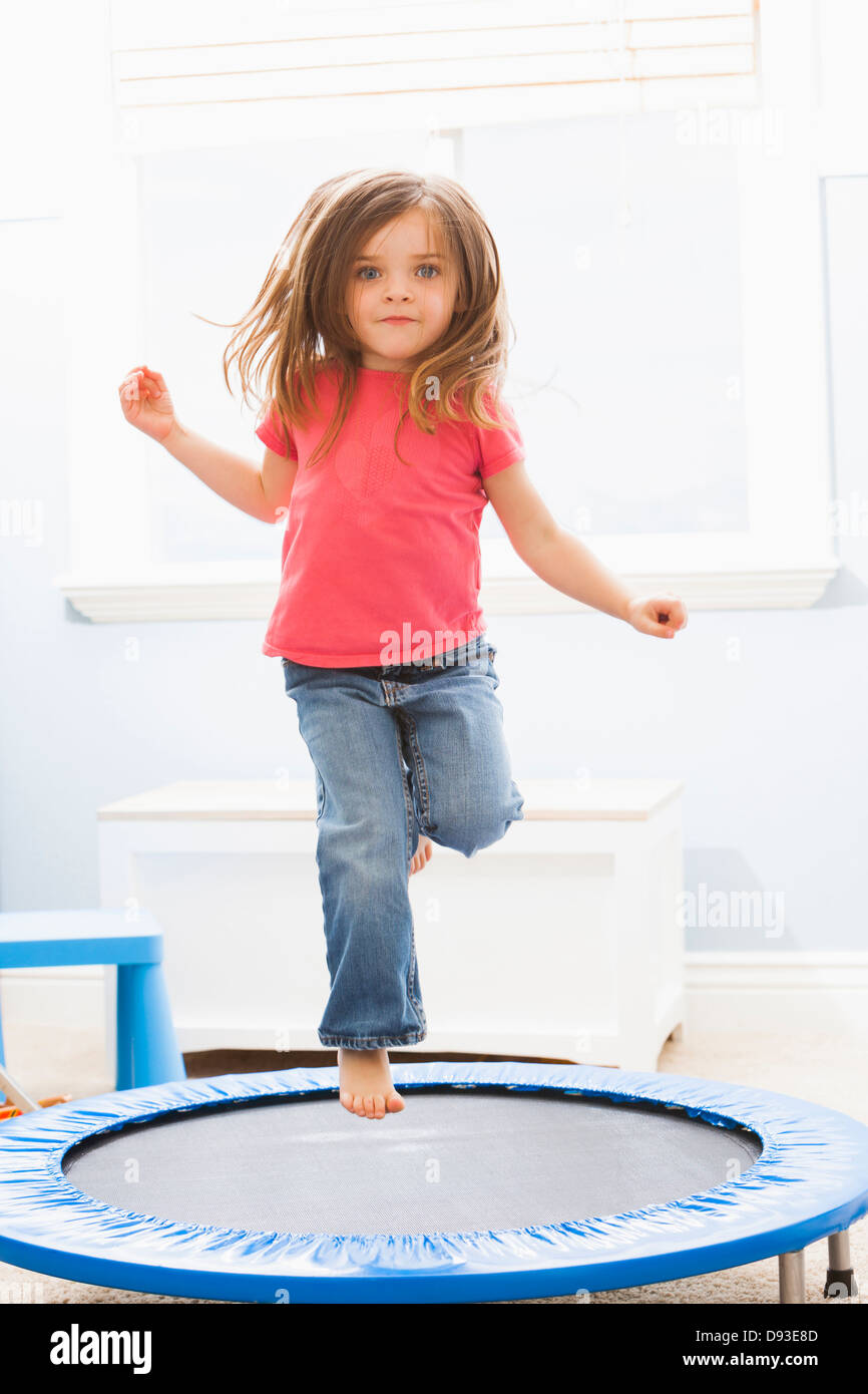 Caucasian girl jumping on trampoline Stock Photo