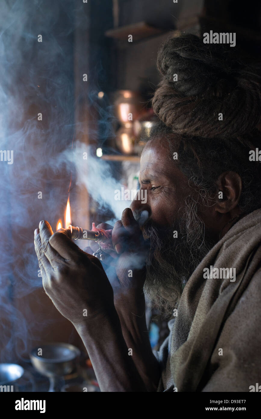 A Hindu Shaivite Sadhu (ascetic) lights a chillum (pipe) in the Himalayan district of Chamba in Himachal Pradesh, India Stock Photo