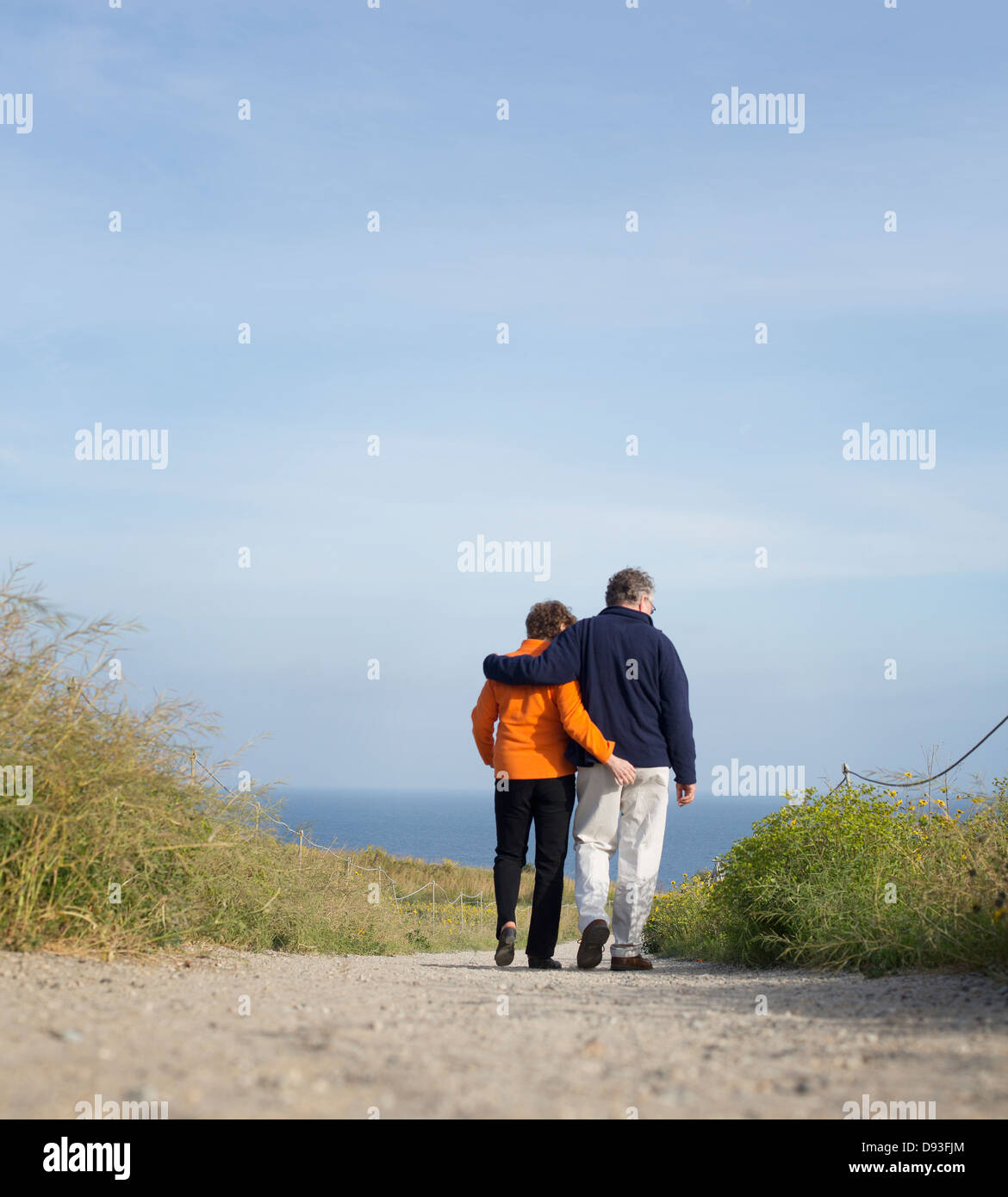 Caucasian couple walking on beach Stock Photo