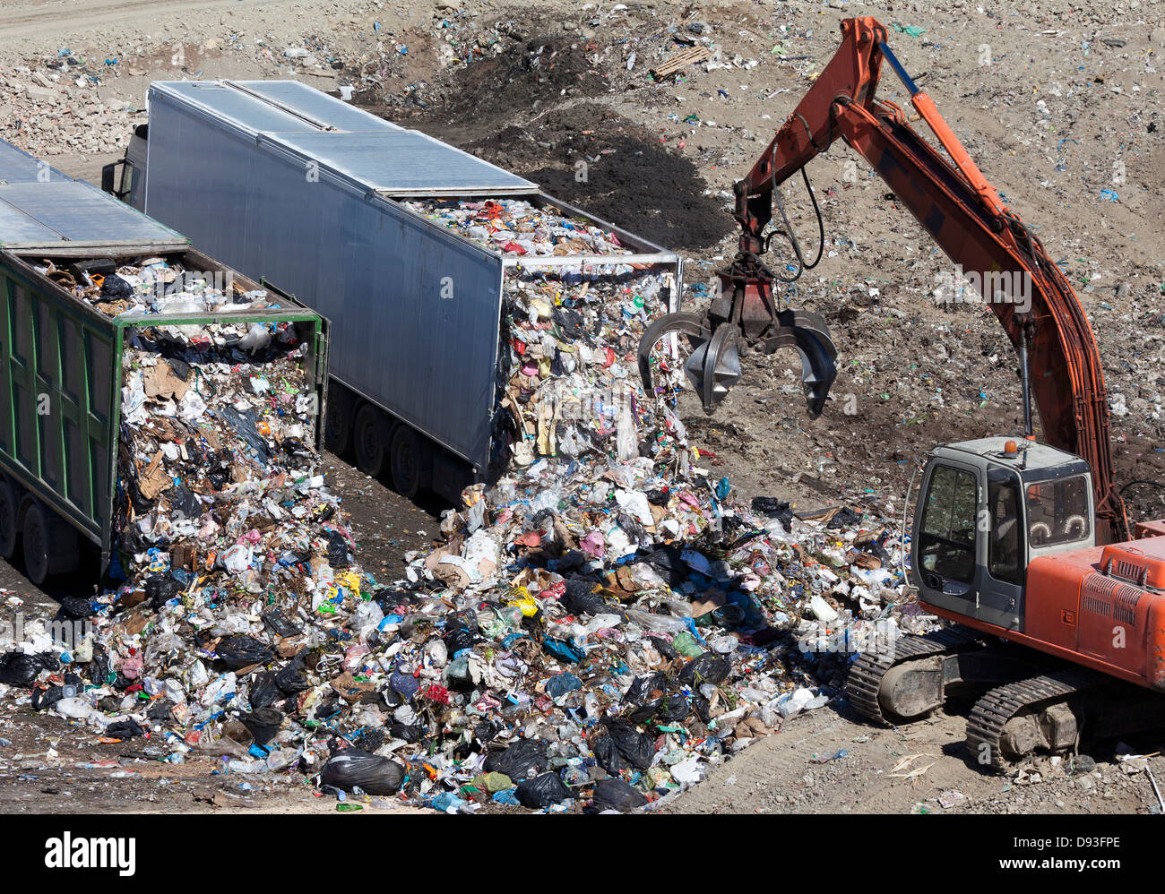 Trucks dumping refuse into landfill Stock Photo