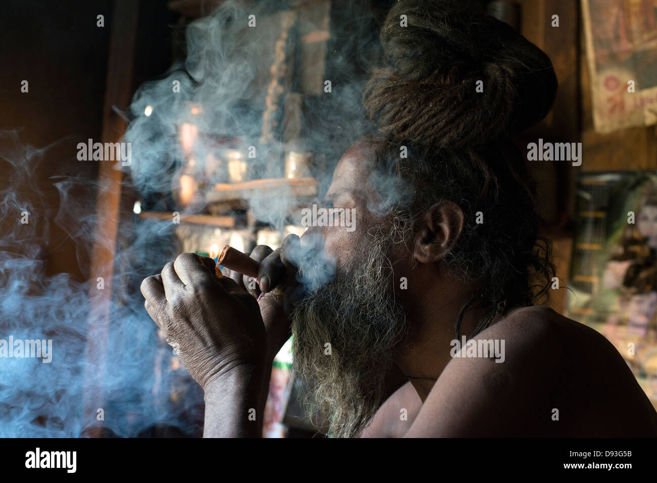 A Hindu Shaivite Sadhu (ascetic) lights a chillum (pipe) in the Himalayan district of Chamba in Himachal Pradesh, India Stock Photo