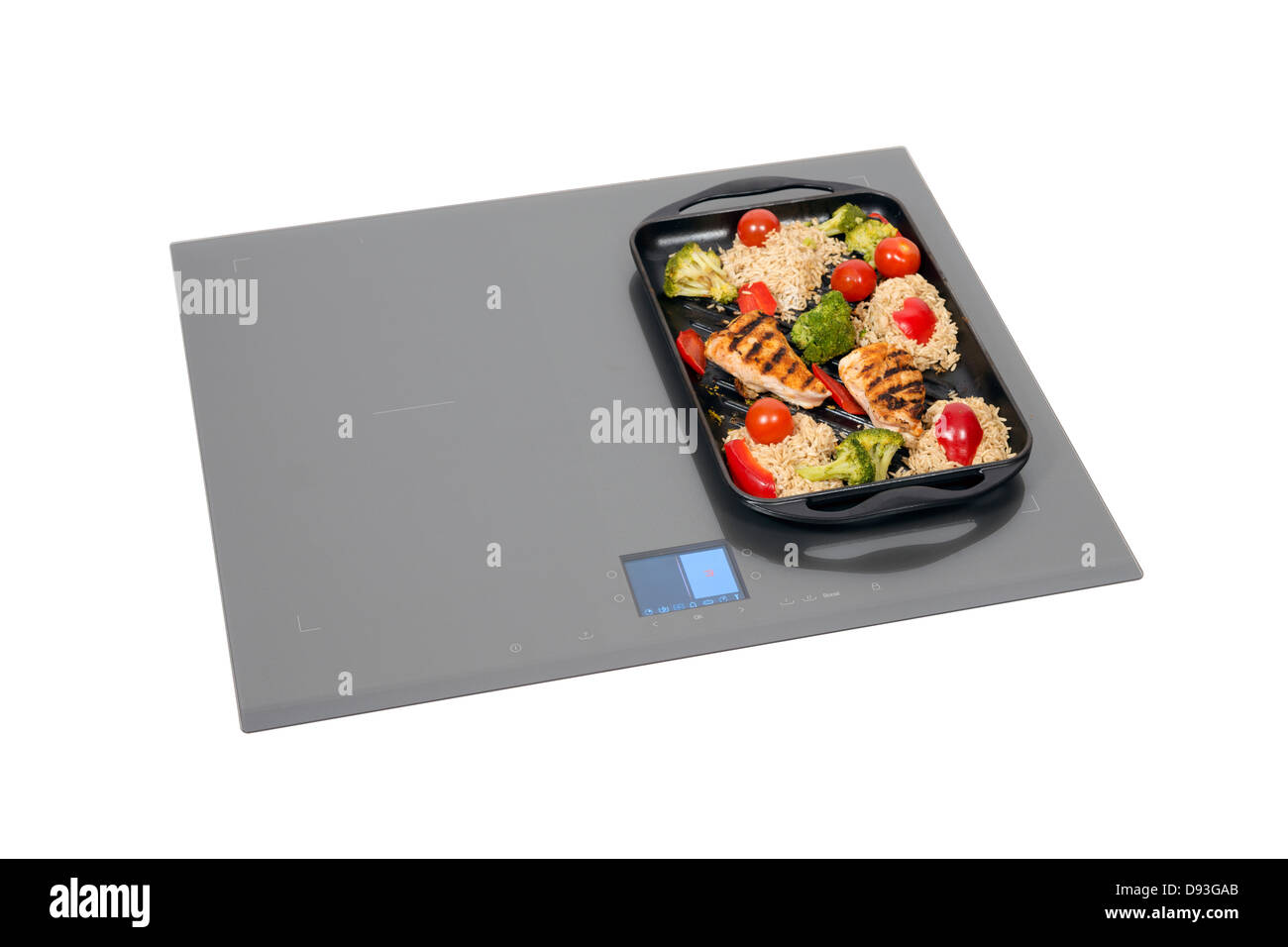 Grey glass induction hob with roast chicken isolated on white. Stock Photo