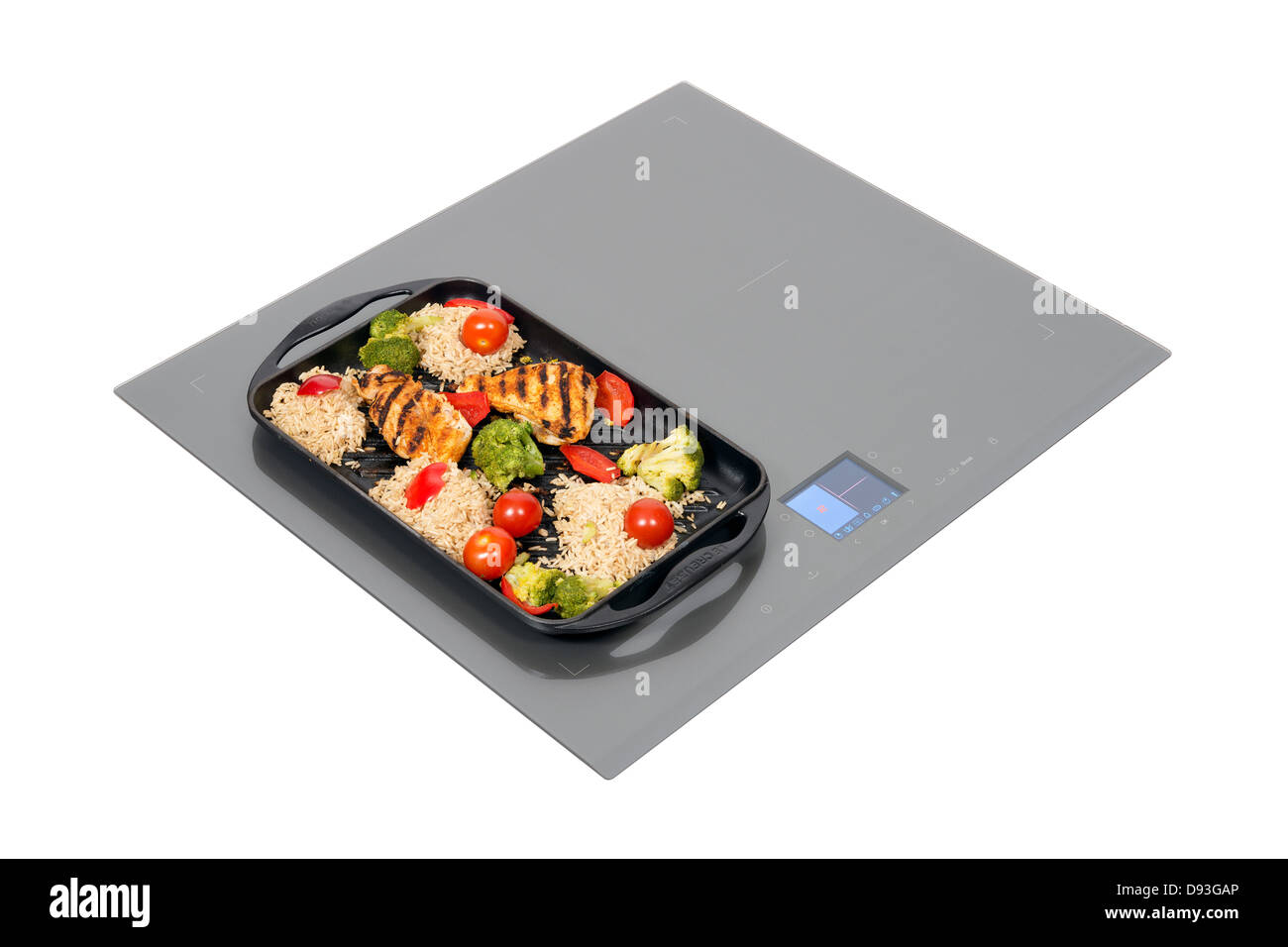 Grey glass induction hob with roast chicken isolated on white. Stock Photo