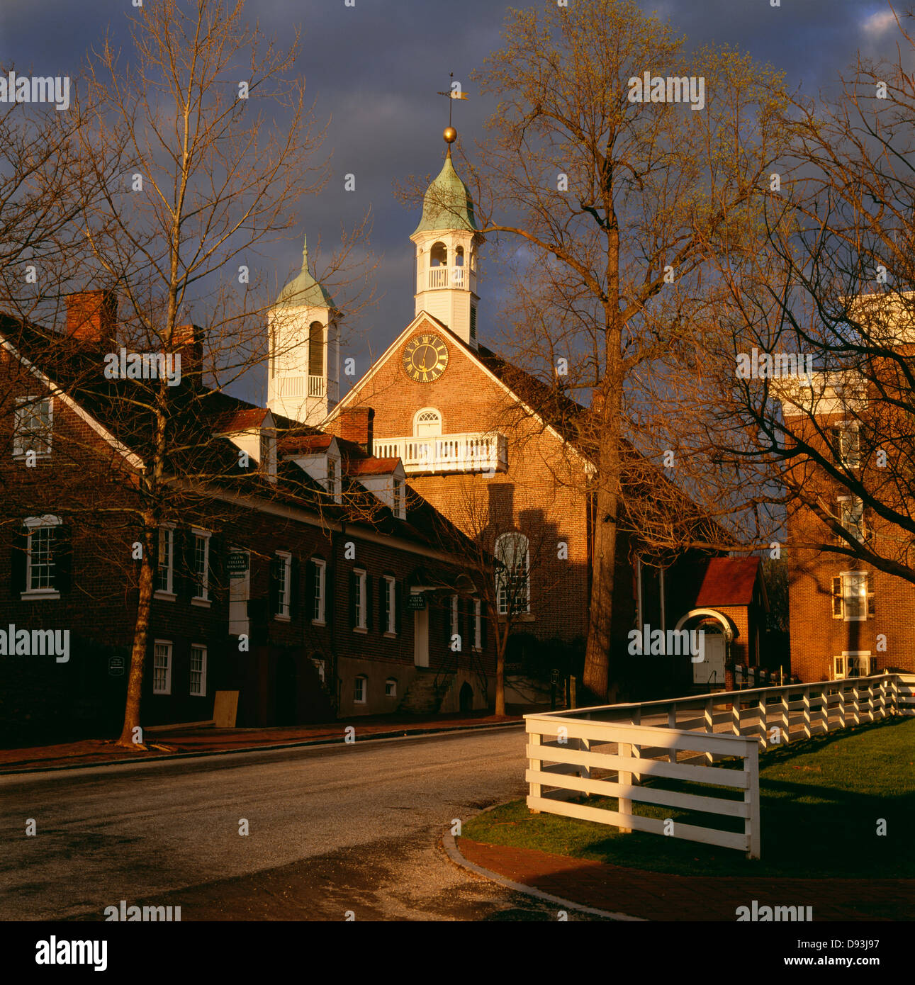 Sunlit church beside road in town Stock Photo