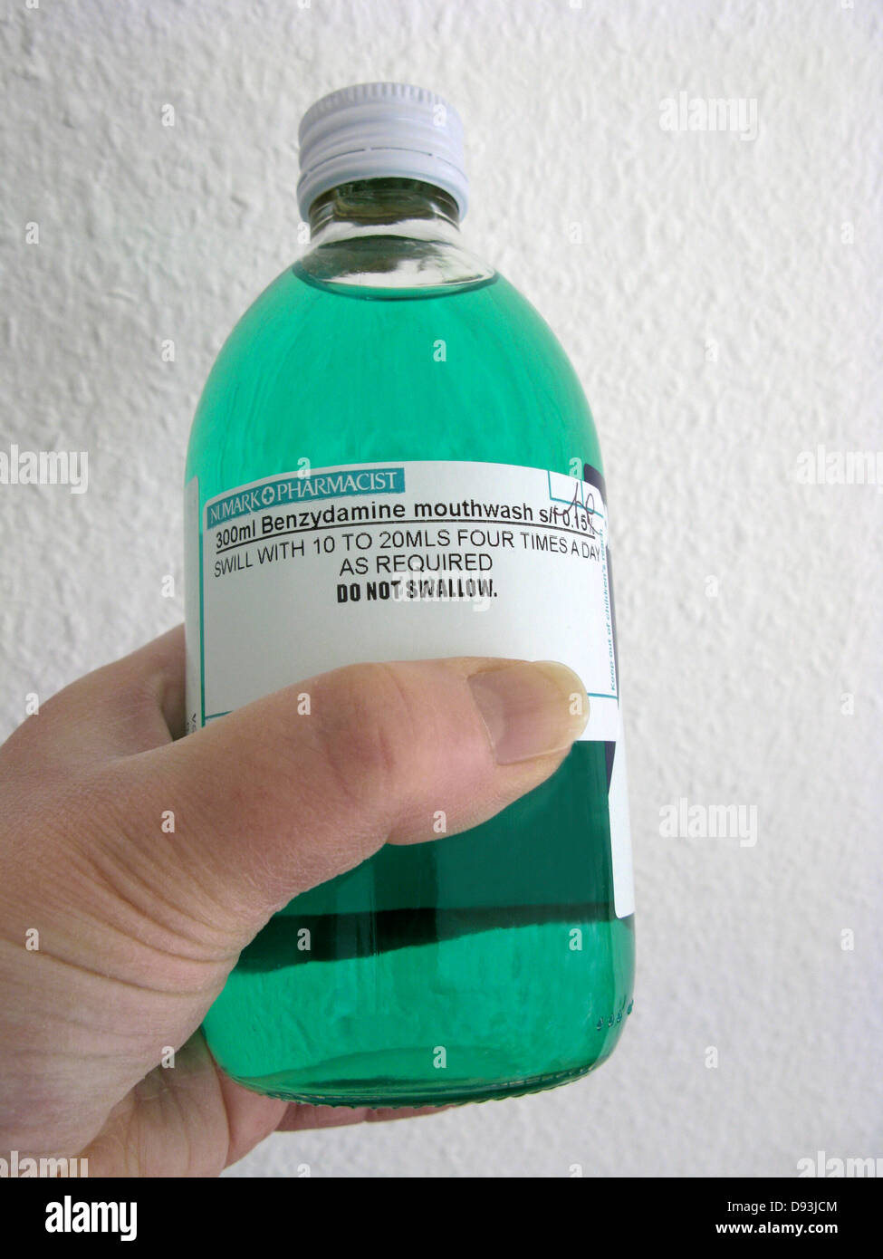 Woman with a bottle of Benzydamine mouthwash to relieve mild to