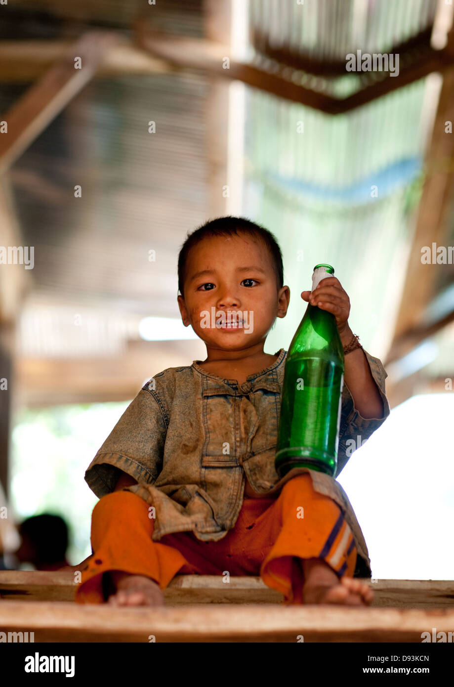 Akha Minority Boy Holding A Beer Bottle, Ban Ta Mi, Laos Stock Photo