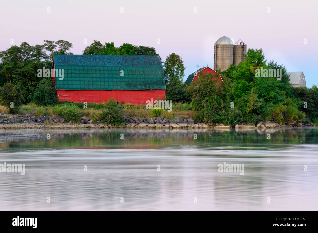 An aging red barn reflected into Gibson Lake waterway hydro controlled