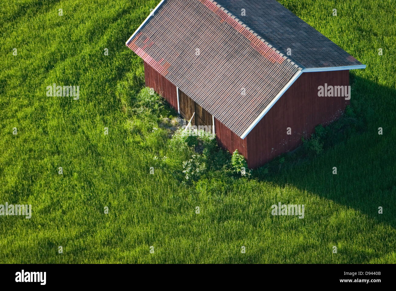 A red cottage on a field, aerial view, Sweden. Stock Photo