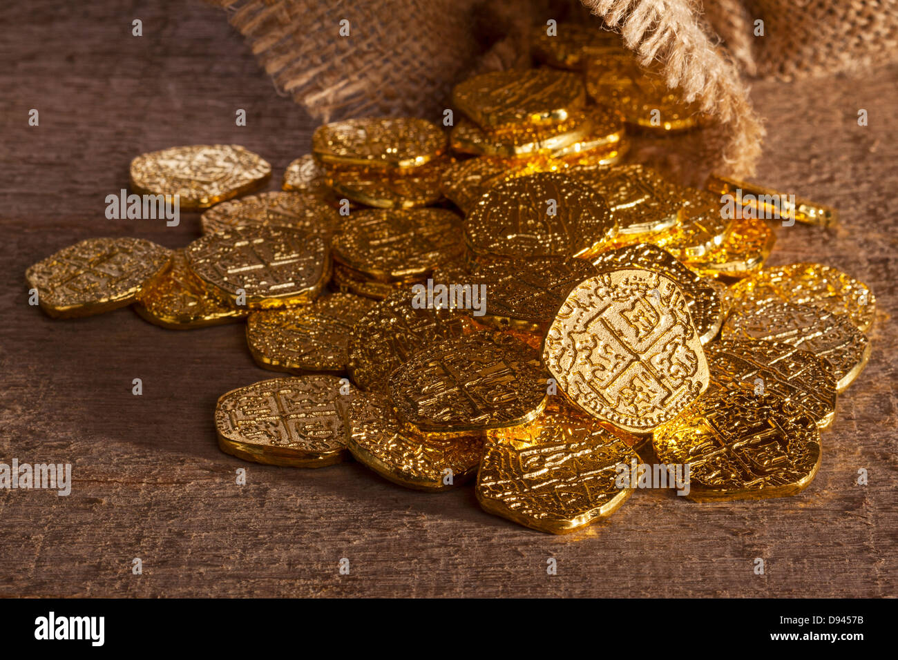 Doubloons Spilling From Sack gold doubloons spilling onto a rough wooden surface from a burlap
