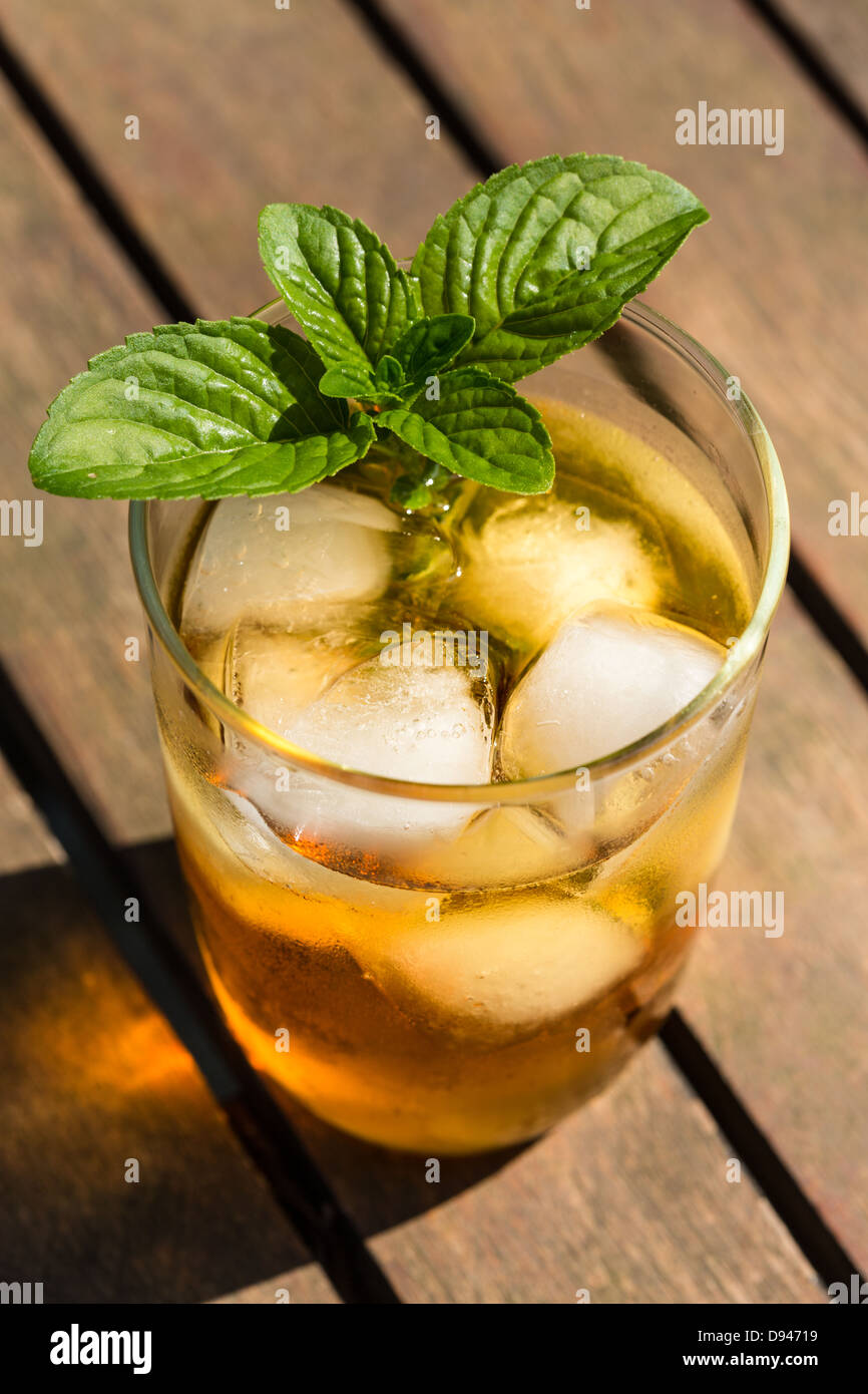 Glass of iced tea with ice-cubes and mint leaves, close-up Stock Photo