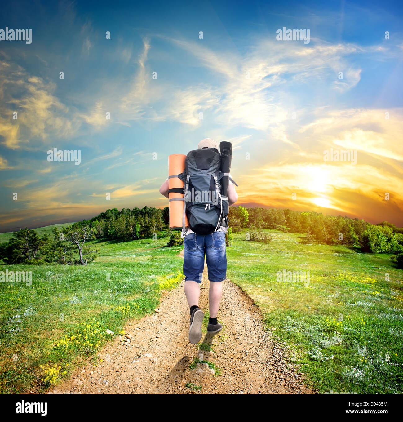 Man with a backpack walking on a country road Stock Photo