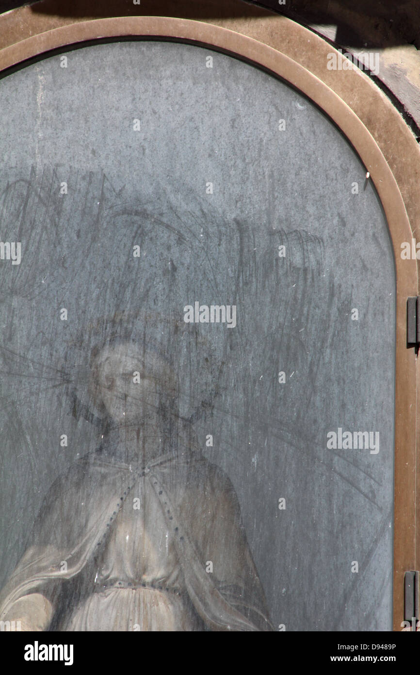 female religious statue in street side altar by church in rome italy