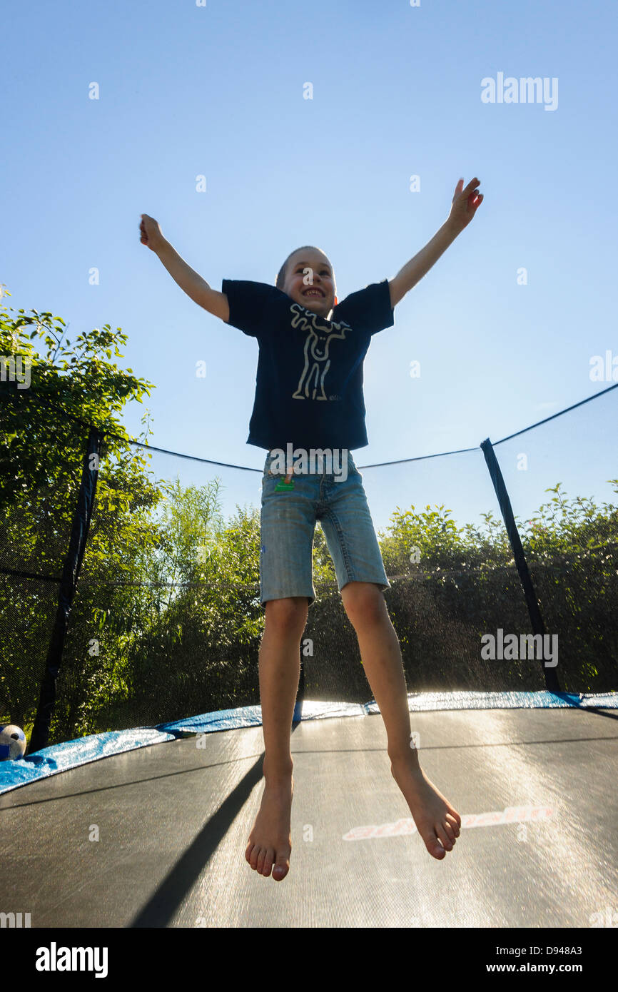 Happy boy jumping on trampoline Stock Photo - Alamy