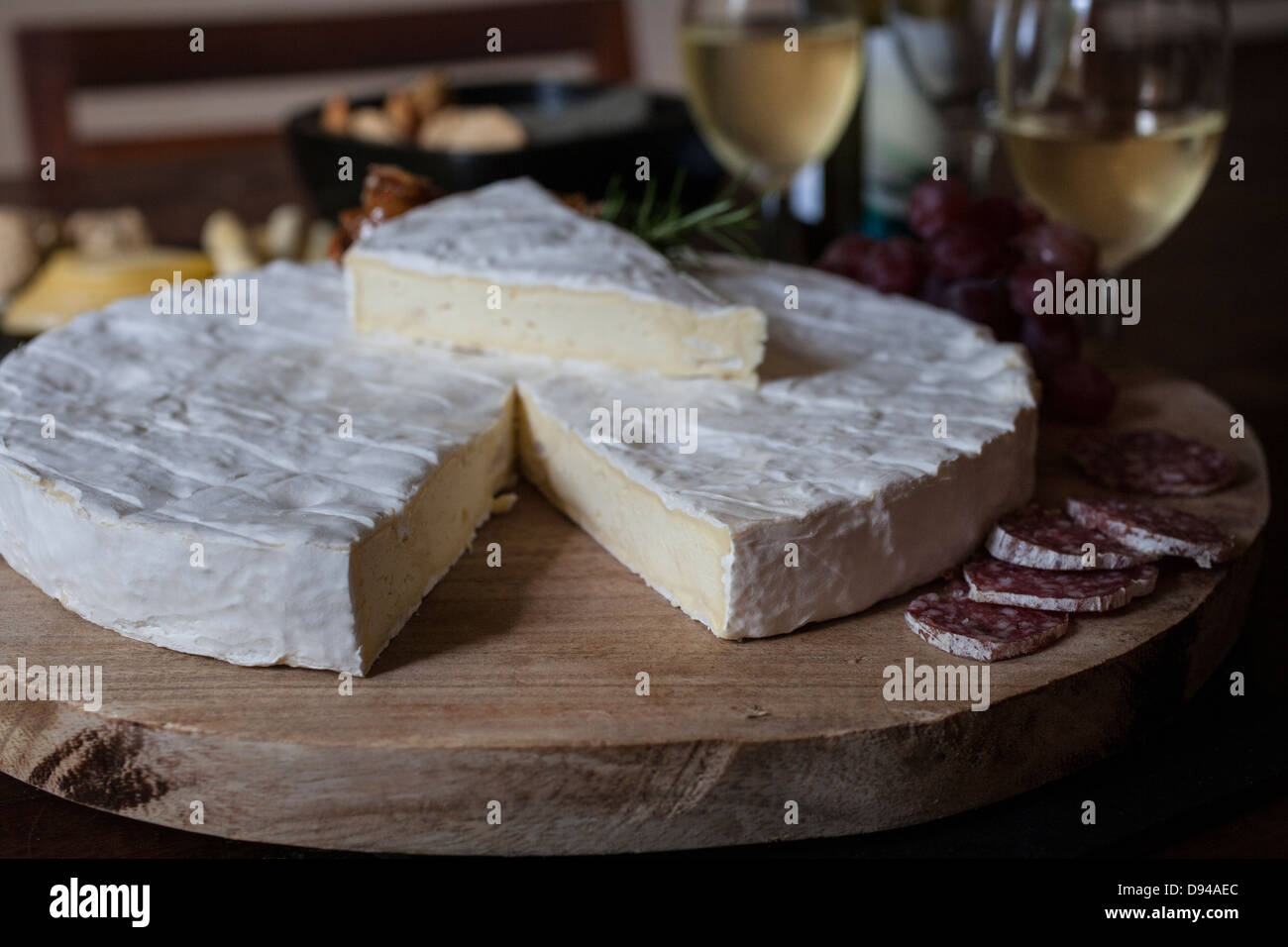wheel of brie cheese with white wine and salamie Stock Photo Alamy