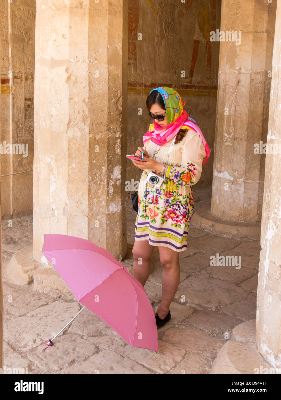 A Japanese Tourist using her smart phone at the temple of Queen Hatshepsut, Egypt Stock Photo