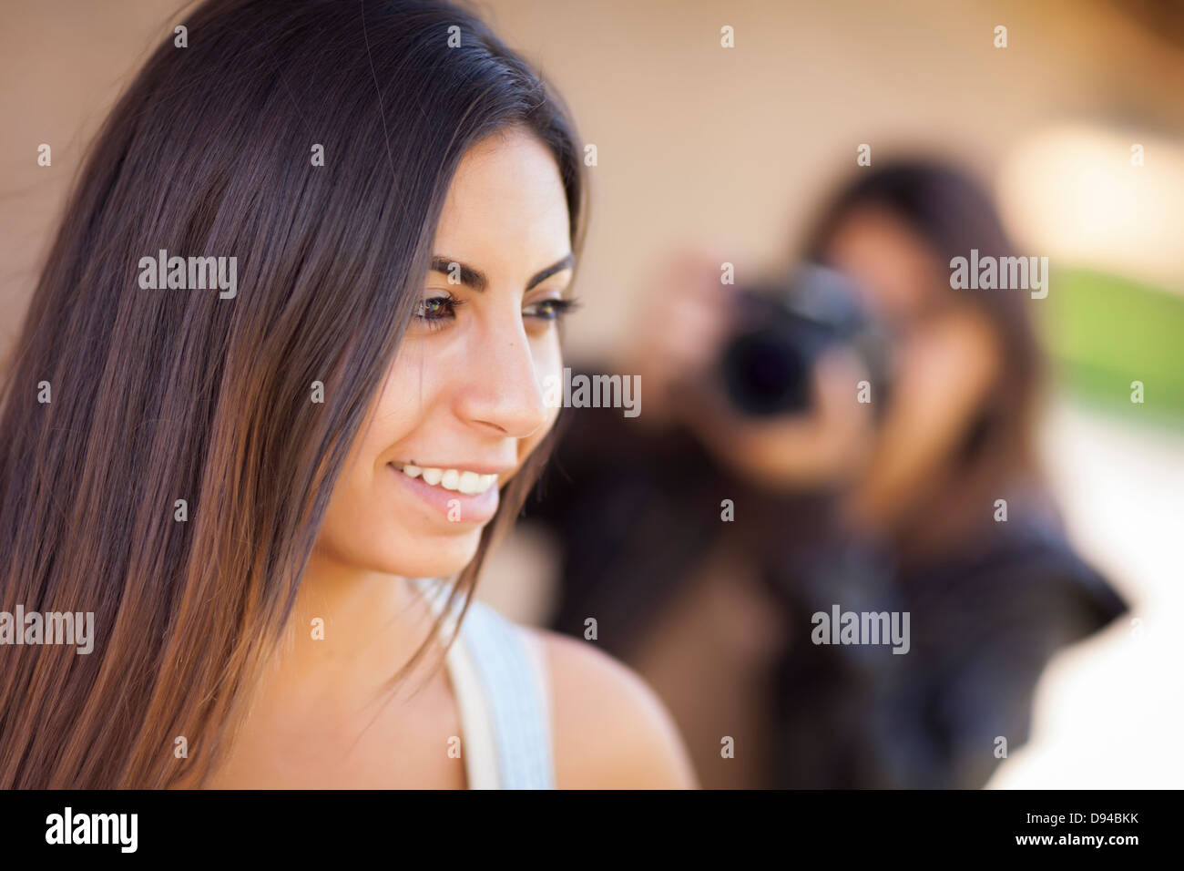 Attractive Young Adult Mixed Race Female Model Poses for a Photographer Outside. Stock Photo