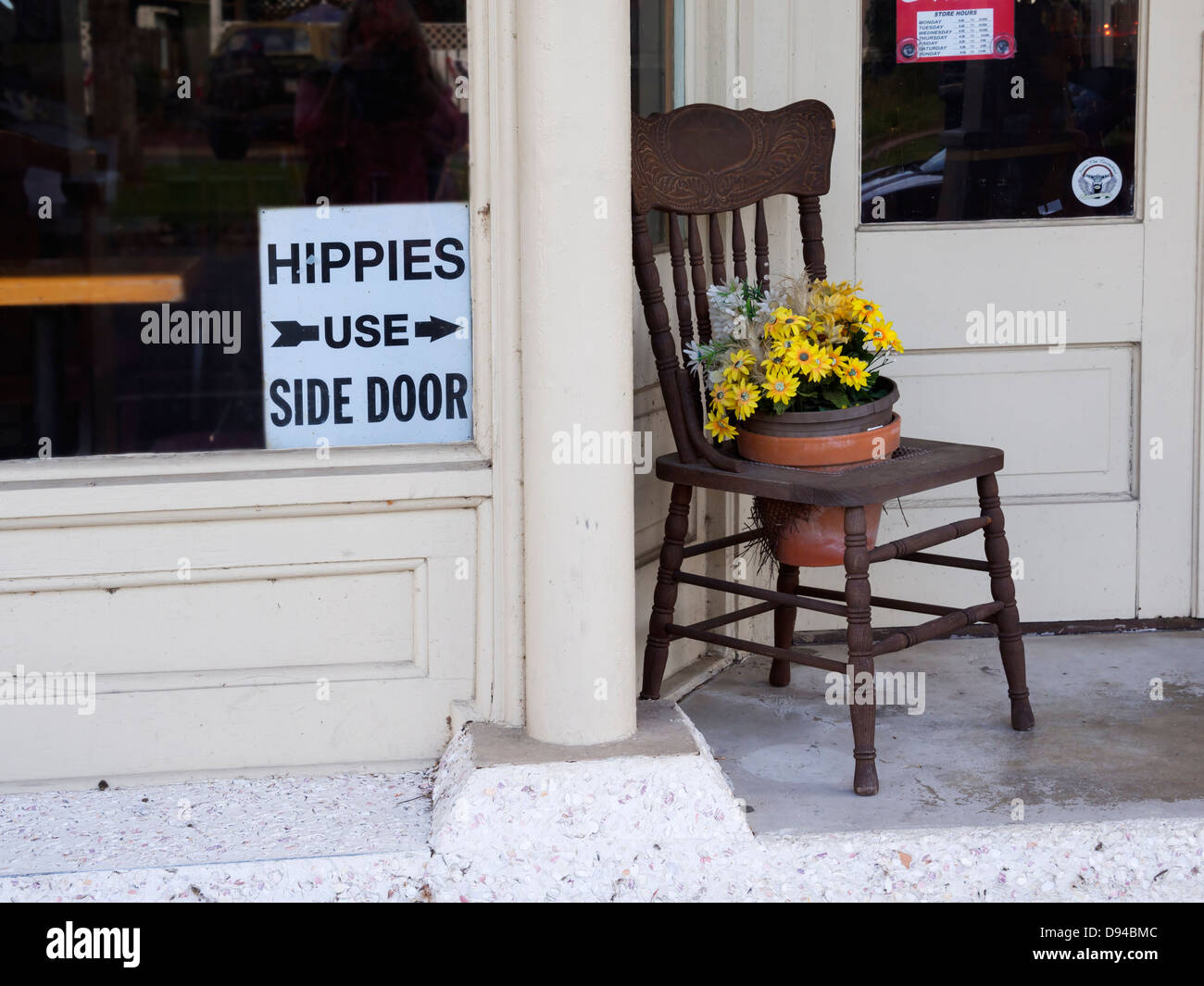 Hippies Use Side Door sign in a window of an old hotel in St Mary's Georgia Stock Photo