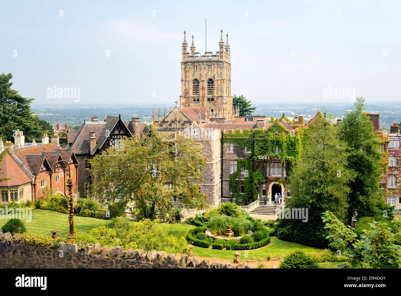 Great Malvern, Worcestershire, England. The tower of the Priory Church of St. Mary and St. Michael rises behind the Abbey Hotel Stock Photo