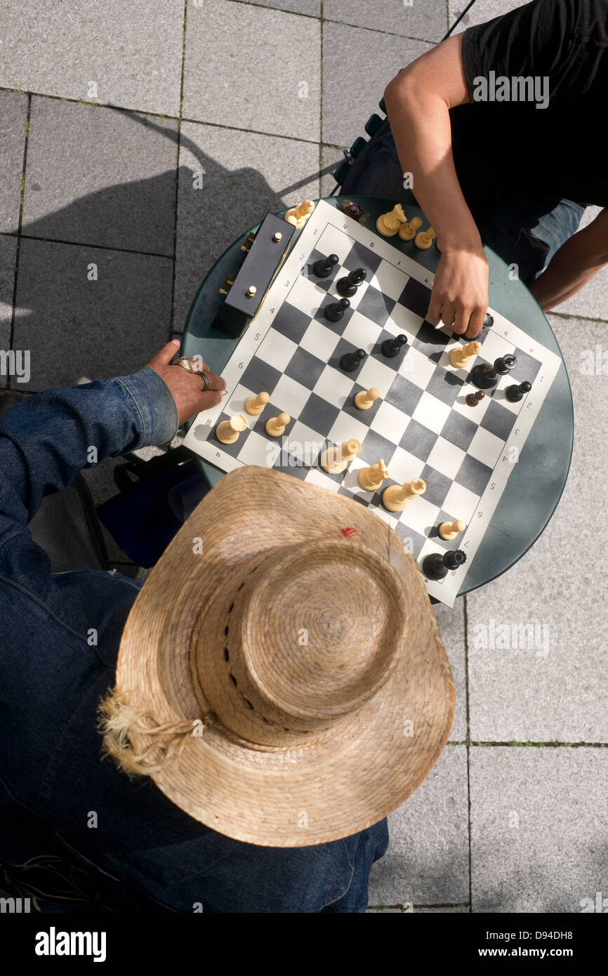 A man moves his Rook in a game of chess on the street Stock Photo