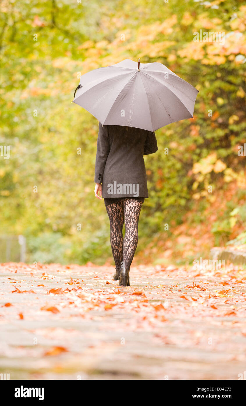 A young woman walking during the rain Stock Photo - Alamy