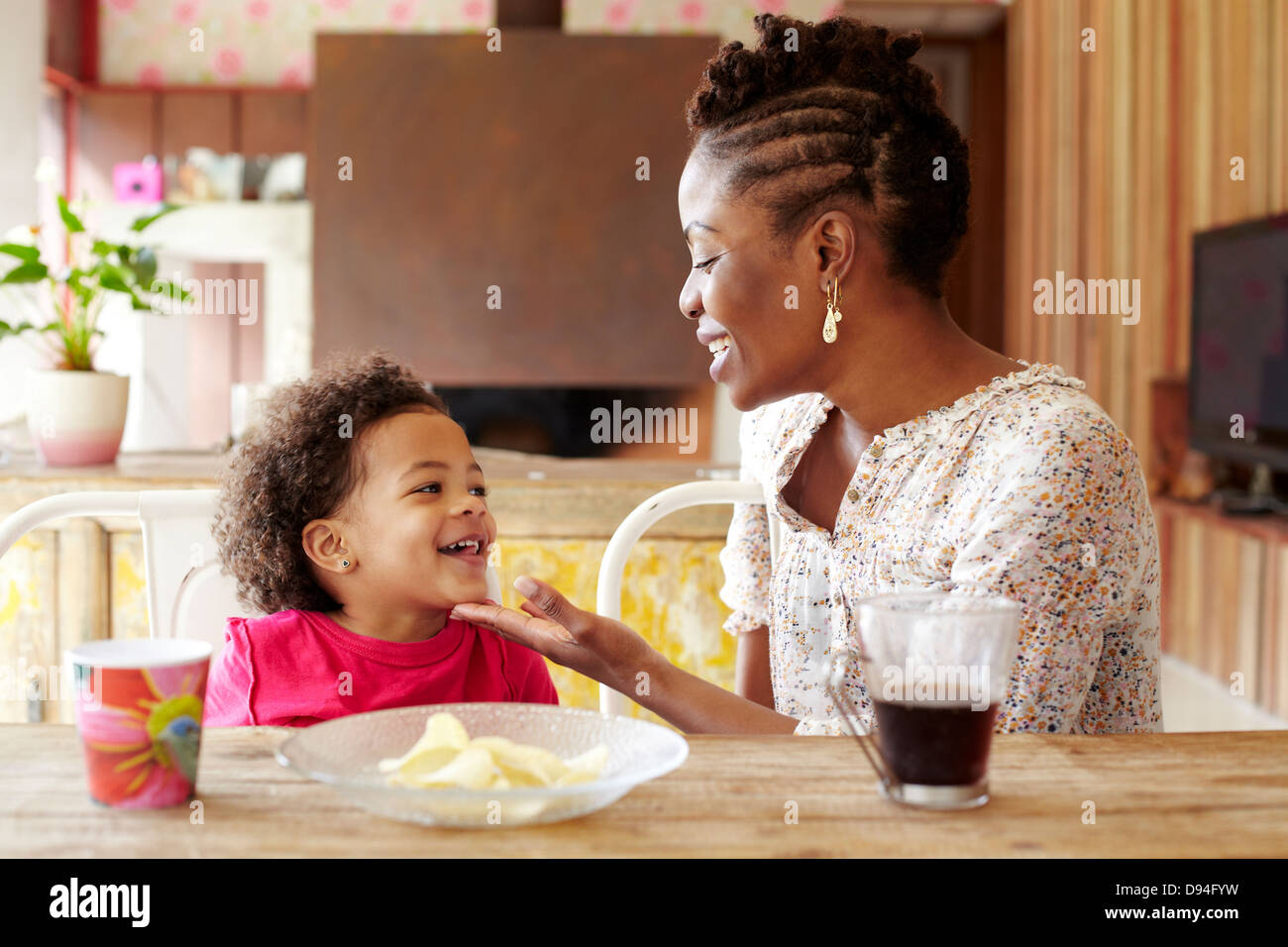 Mother and daughter talking at breakfast table Stock Photo