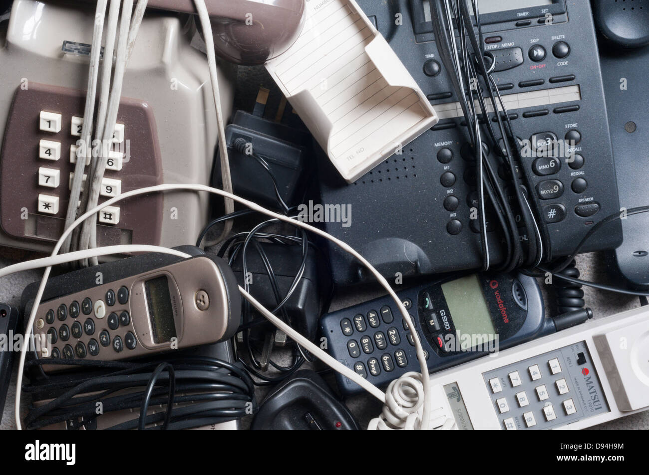 A pile of dusty old telephones awaiting recycling. Stock Photo