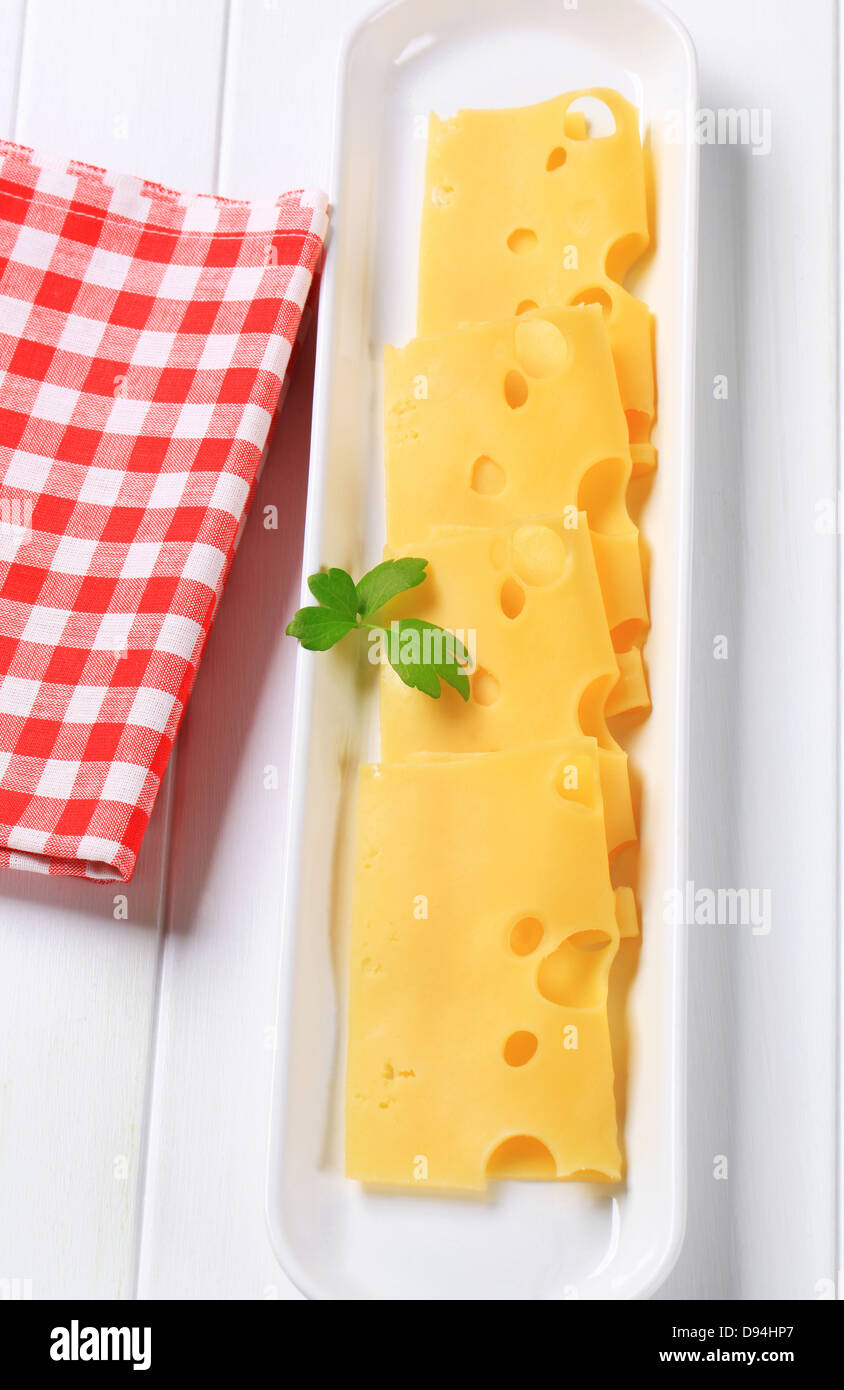 Thin slices of Swiss cheese in a long serving dish Stock Photo