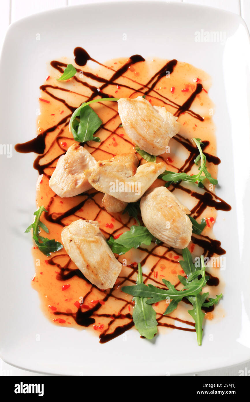 Seared chicken pieces with chili sauce and balsamic vinegar drizzle