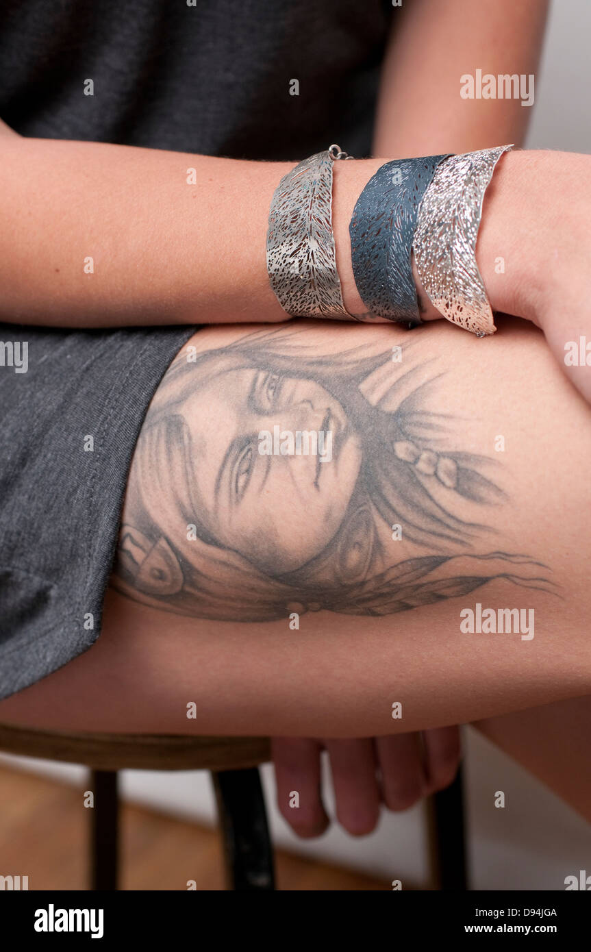 A hip and trendy young woman with a tattoo of a squaw on her thigh Model release available Stock Photo